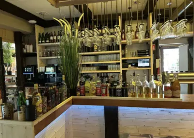 Barkeeperbereich mit verschiedenen Flaschen und Gläsern auf Regalen in einem Restaurant.