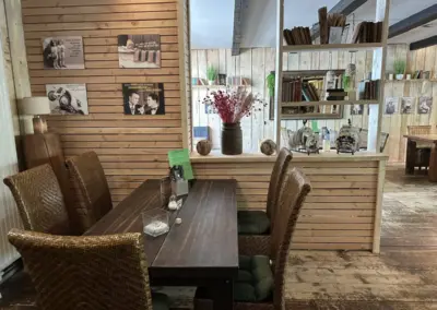 Ein Holztisch mit vier Stühlen in einem Restaurant mit Holzverkleidung und Dekoration.